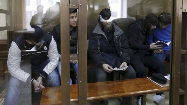 The five defendants in a glass cage in Moscow's court