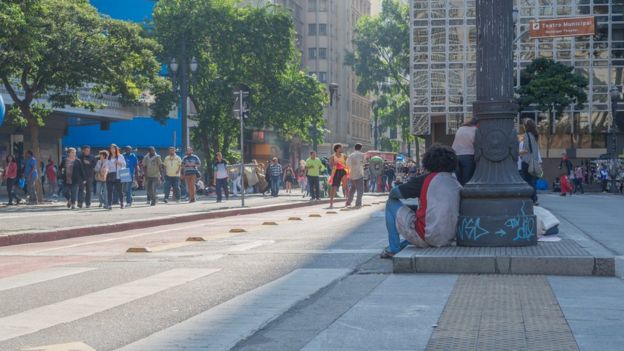 Imagem mostra homem sentado no centro de São Paulo