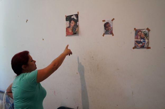 Tania Pérez Mederos, la mujer de Roberto Luis Beltrán, señala una de las fotos pegadas a la pared de su habitación en Adasevci, Serbia.