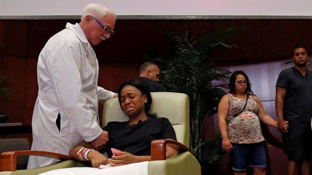 Una paciente llora y un médico le sujeta la mano