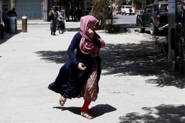 AnAfghan women runs away during gun fire at the site of an attack in Kabul, Afghanistan 31 July 2017.