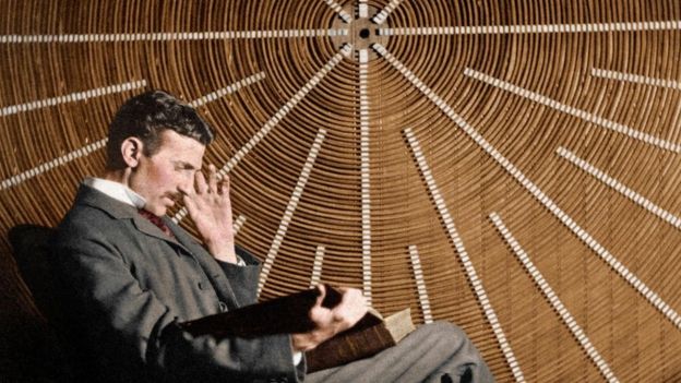 Nicola Tesla, sentado, leyendo un libro