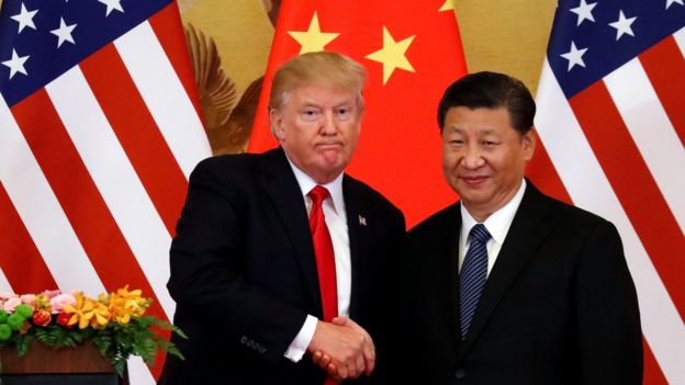 Donald Trump y Xi Jinping se saludan.