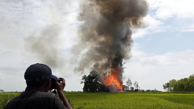 Journalist take photos of a burning house at the Gawdu Zara village in Maungdaw township, Rakhine State, western Myanmar, 7 September 2017