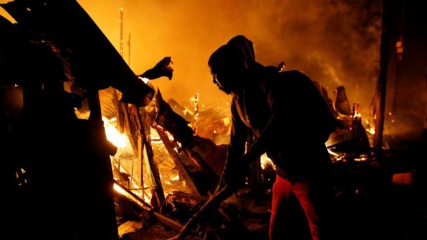 A resident attempts to extinguish a fire that broke out at the Kijiji slums in the Southlands estate of Nairobi, Kenya, January 28, 2018.