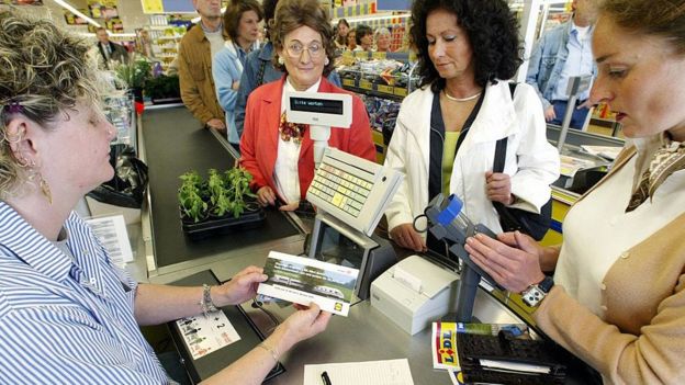 Una cajera en un supermercado atendiendo a clientes