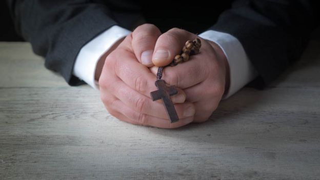 Man in suit with a crucifix