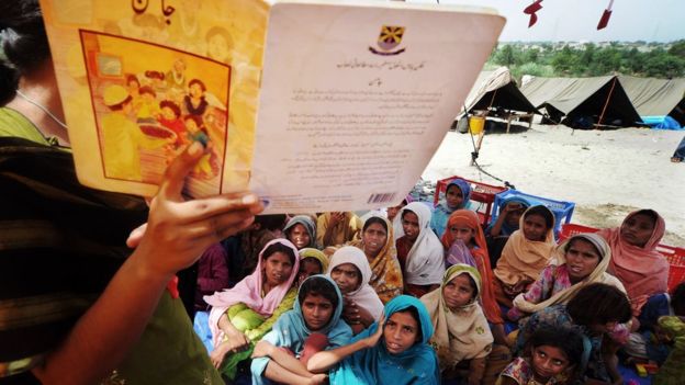 Niñas pàquistaníes escuchan mientras su maestra les lee.