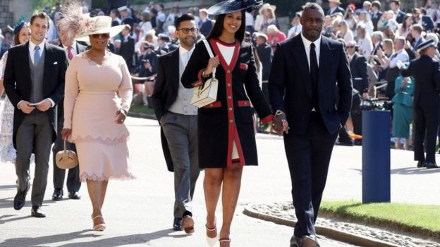 US TV star Oprah Winfrey, wearing pink, and British actor Idris Elba arrive at the chapel