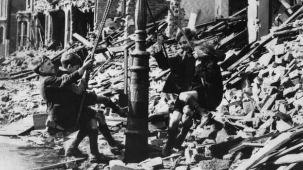 Crianças brincando em destroços de bombardeio da Segunda Guerra em Londres