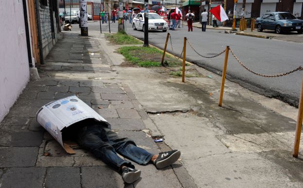 Vagabundo duerme en la calle metido en una caja de cartón en San José, Costa Rica, el 29 de abril de 2010.