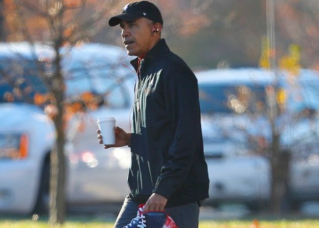 Obama en una caminata con un café en la mano.