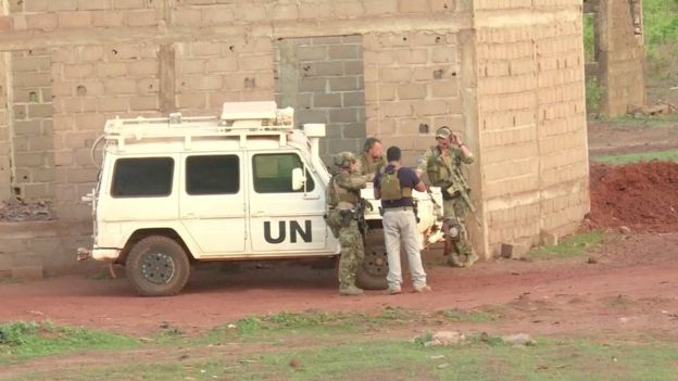 French soldiers stand around a United Nations vehicle following an attack where gunmen stormed Le Campement Kangaba in Dougourakoro