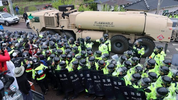 riot police surrounding a Thaad missile system as it is transported