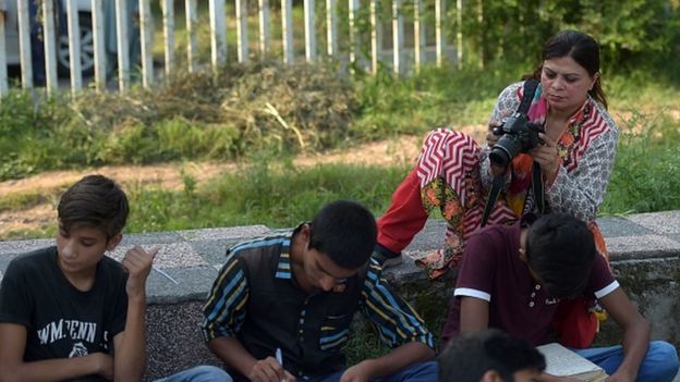 A journalist shoots video footage during an assignment in Islamabad (30 August 2016)