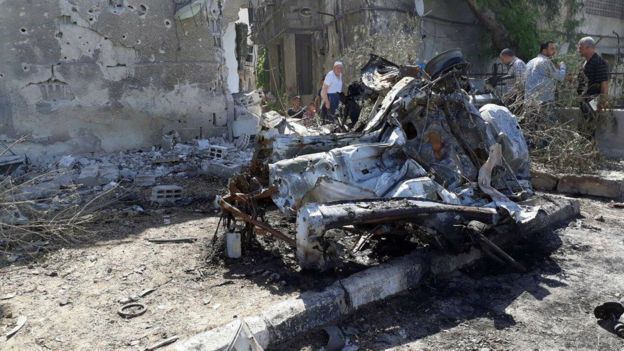 La gente inspecciona los restos de un coche bomba en Damasco. 2 de julio de 2017
