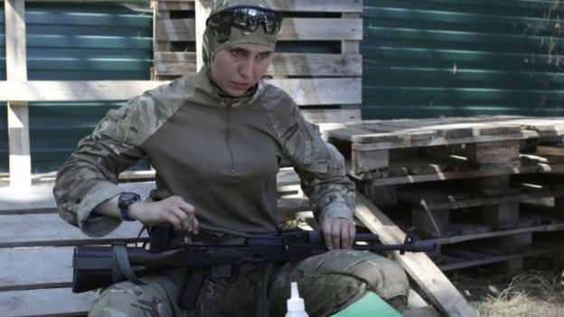 Volunteer fighter Amina Okuyeva cleans her assault rifle. Photo: July 2014