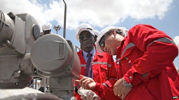 South Sudan's Minister for petroleum and mining prepares to press the button which will resume oil production after a 16-month hiatus in an oil production facility in Paloch in South Sudan's Upper Nile state, on 5 May 2013