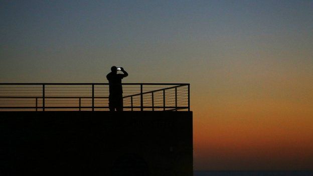 A man takes a picture with his mobile phone