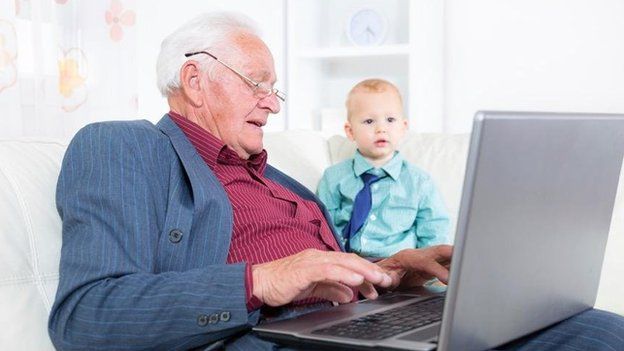 Old man with laptop watched by baby