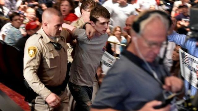 Police led the suspect away at Saturday's rally