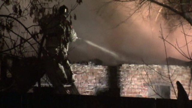Firefighter spraying water at fire