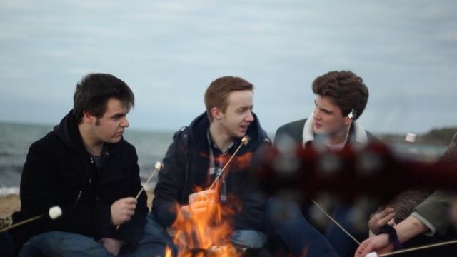 Young people sitting at a campfire