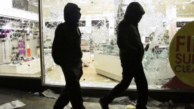 Young men outside looted shop
