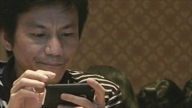 A Thai man tries out a 3G phone