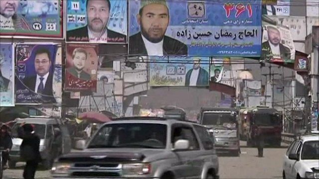 Cars driving under campaign posters