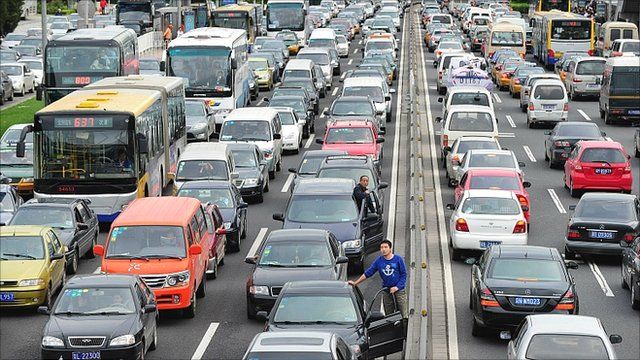 Drivers step out of their vehicles for a better view while stuck in traffic along Beijing's second ring road