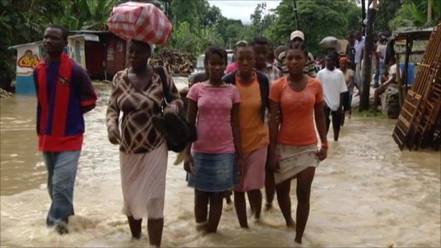 People walking through the flooded street