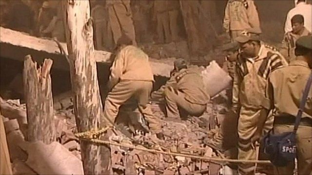 Emergency workers sort through the rubble