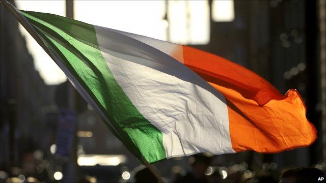 Irish flag being waved outside government buildings in Dublin