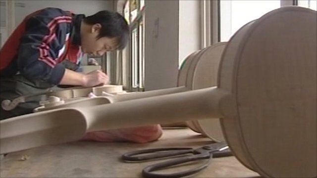 Migrant worker making violin