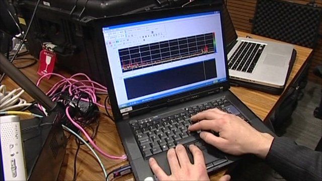 Laptop surrounded by surveillance equipment
