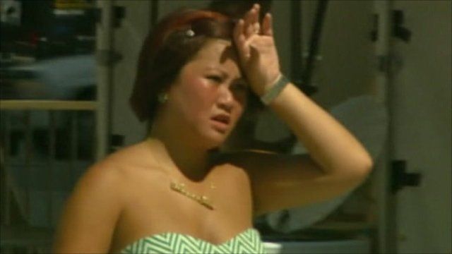 Woman puts hand to head