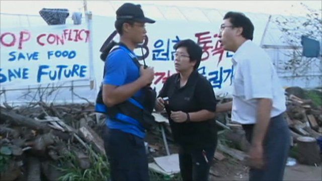 Protesters talking to security man outside Jeju protest camp