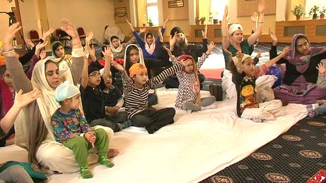 Children and their mothers worshipping at a Sikh temple in London