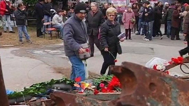 People lay flowers at memorial