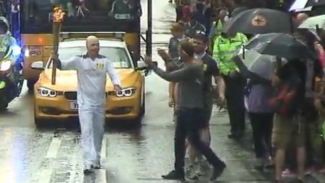 Man approaches torch carrier