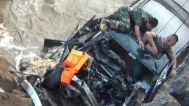A rescuer helping the driver to safety
