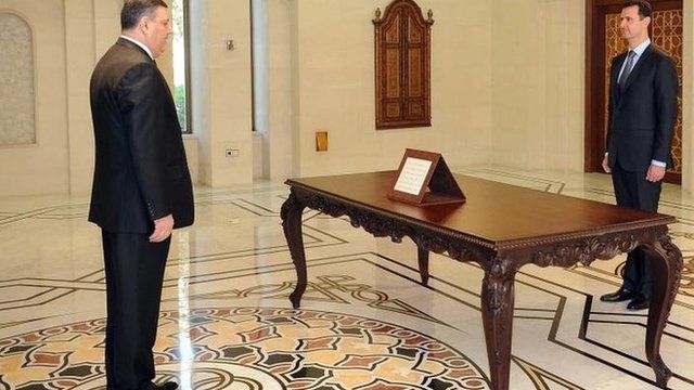 Syrian news agency picture of former Prime Minister Riad Hijab (L) being sworn in on 26 June in front of President Assad