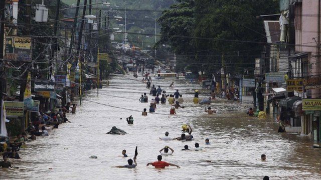 Residents negotiate a flooded street