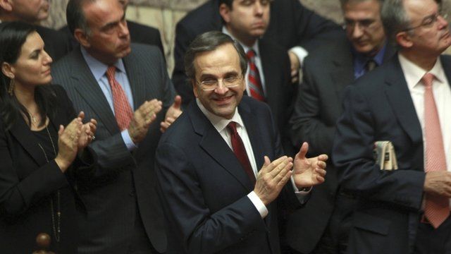 Greece"s Prime Minister Antonis Samaras and his party's lawmakers of the New Democracy party applaud after voting on the country's 2013 budget