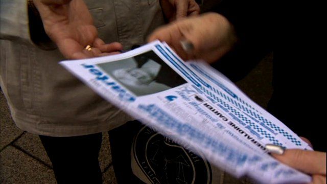 A candidate holding campaign leaflets