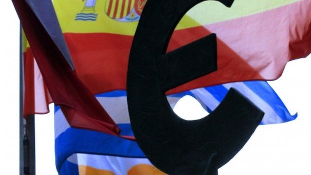 Spanish, Greek and Irish flags fly behind a statue symbolising European unity outside the European Parliament in Brussels