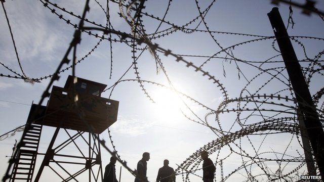 Turkish workers work to reinforce the border fence between the northern Syrian town of Ras al-Ain and the Turkish border town of Ceylanpinar
