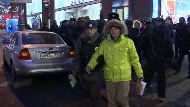 A policeman escorting a protester on to a coach