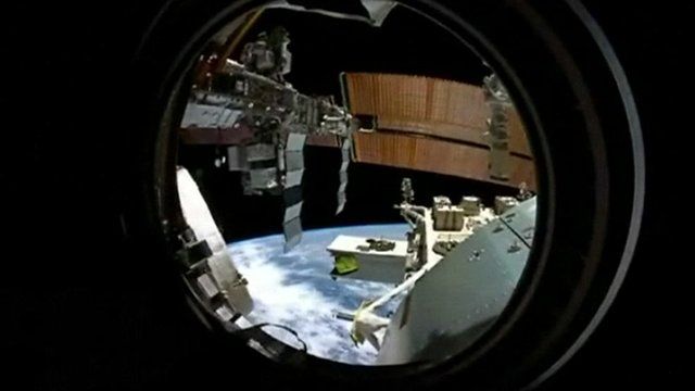 View of the ISS and Earth from one of the space station's portholes